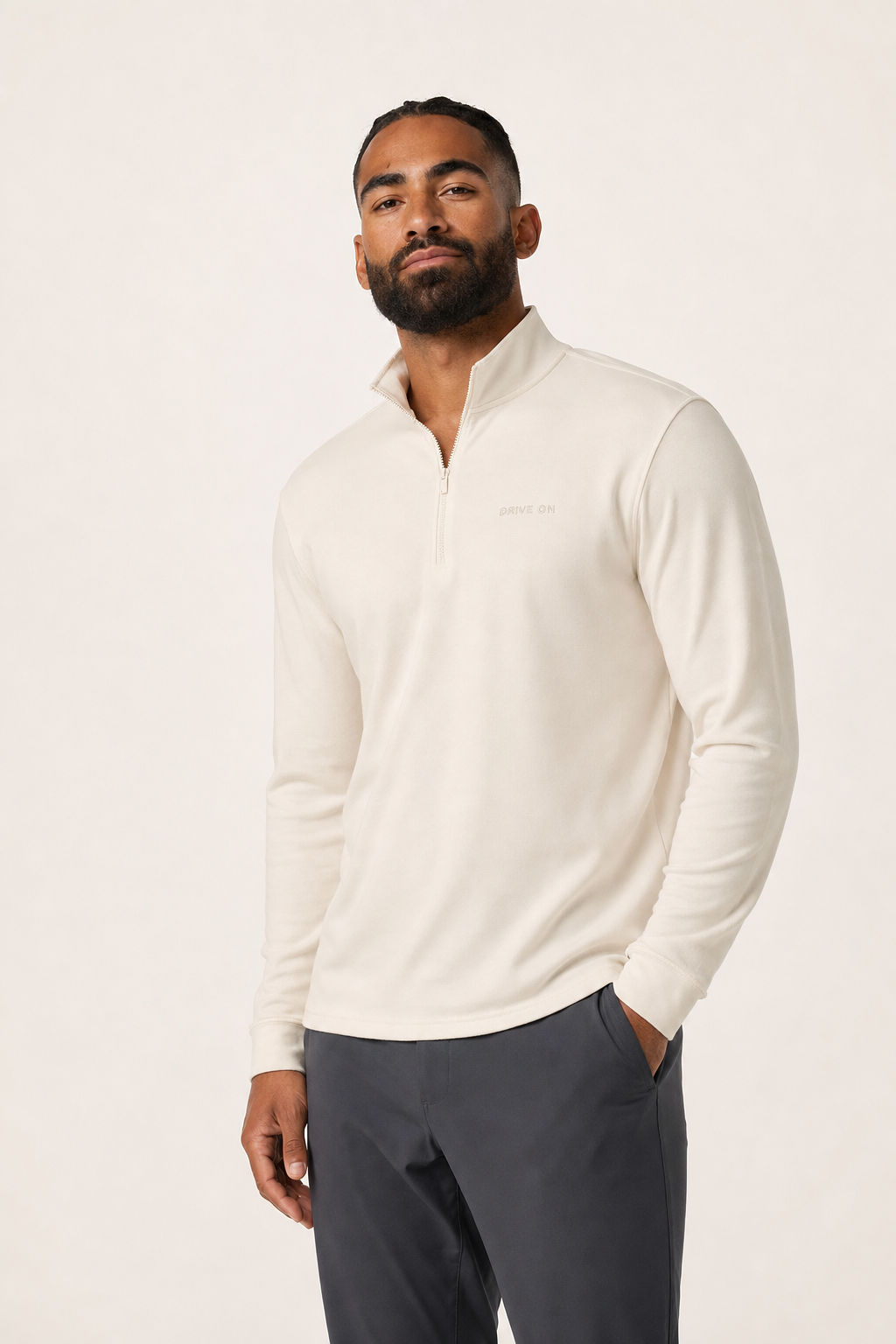 The cream quarter-zip photographed against a plain bone ground