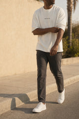 The Cream Graphic Tee worn open-hemmed on a sunlit pavement, DRIVE ON printed small at the chest